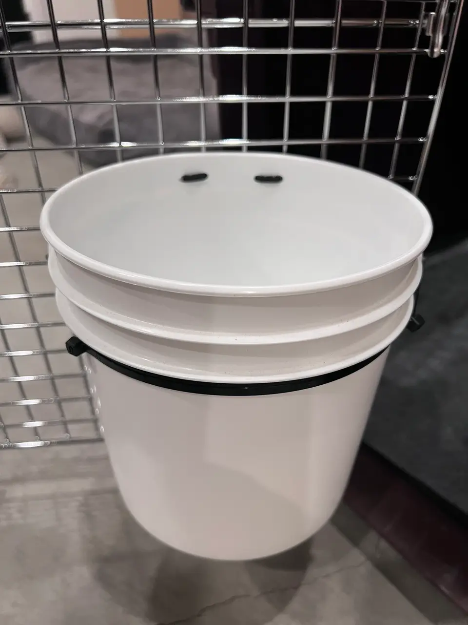 gallon bucket attached to travel crate with additional reinforcements with zipties