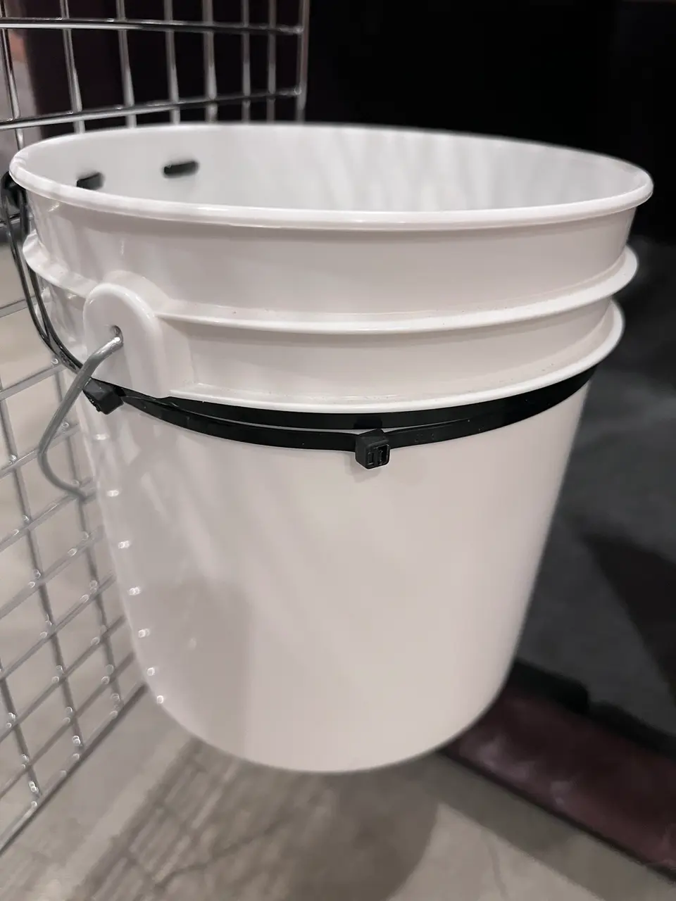 gallon bucket attached to travel crate with additional reinforcements with zipties