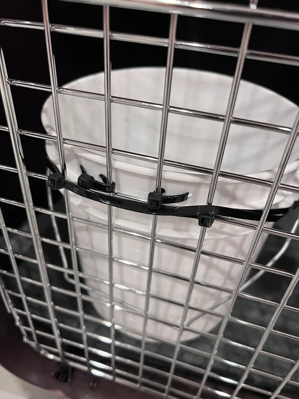 gallon bucket attached to travel crate with additional reinforcements with zipties